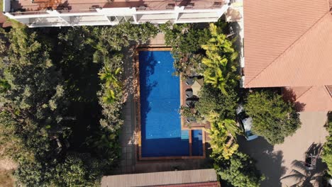 ascending drone shot of a tropical hotel grounds and swimming pool