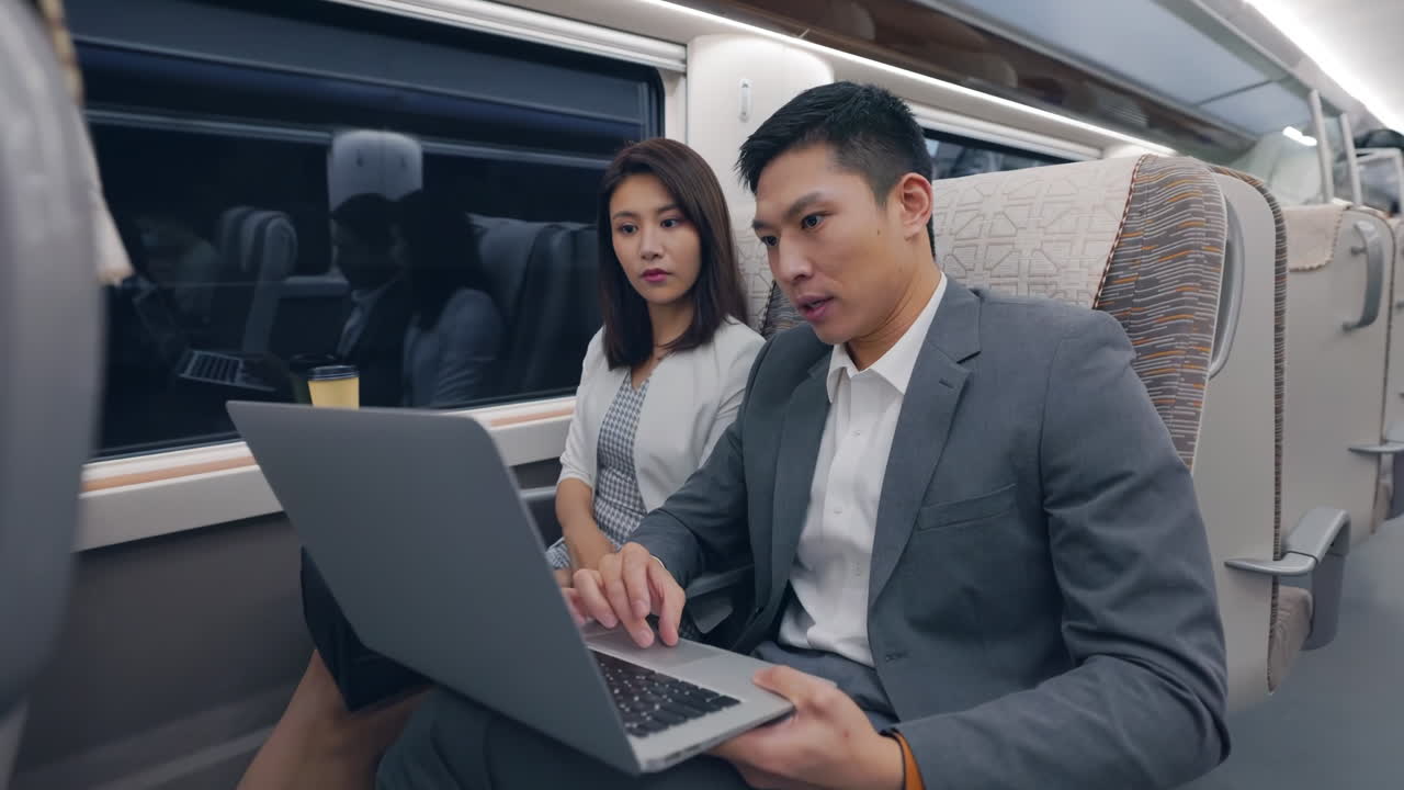 Teammate busy meeting strategy business team gathered around a table in train moving, discussing strategies for the upcoming quarter, using laptops and charts to analyze data and make decisions