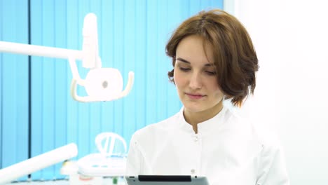 female dentist working on tablet in dental office