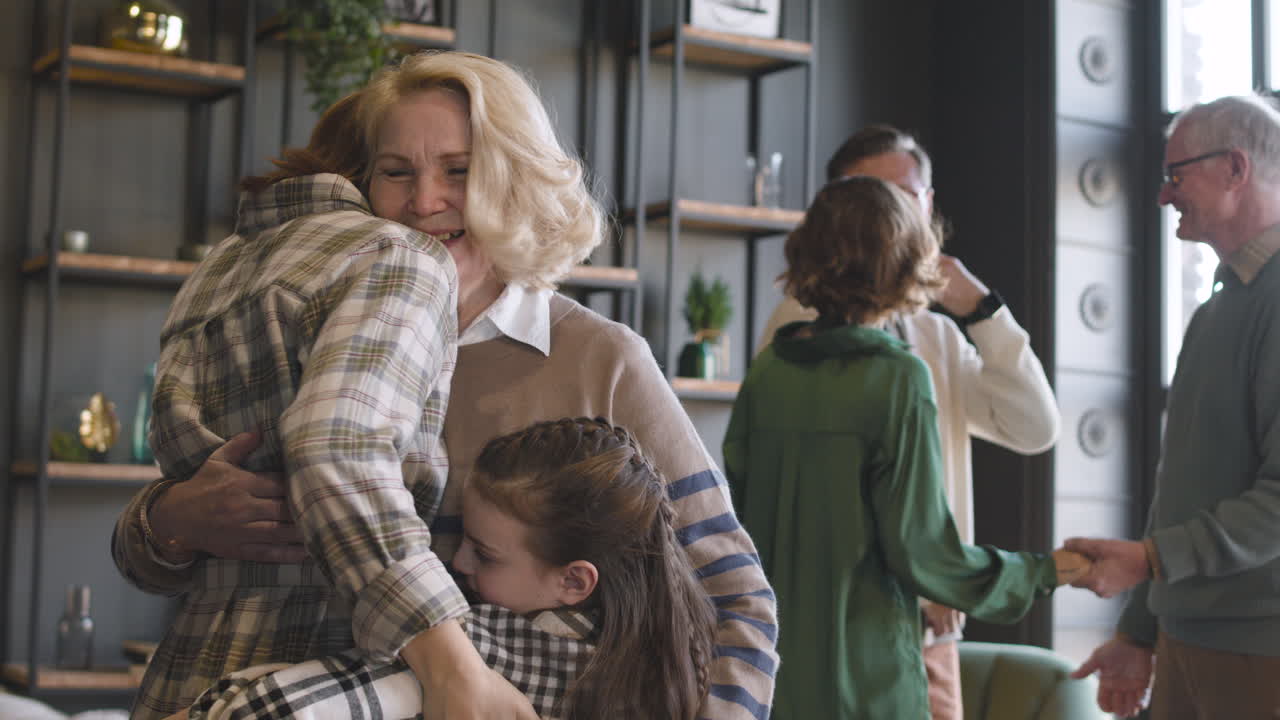 abuela, madre y niña abrazándose juntas durante la reunión familiar en casa