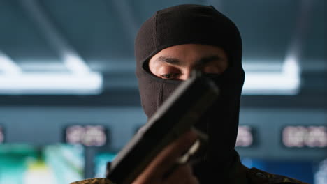 portrait of terrorist loading gun, attacking enemy command center, close up