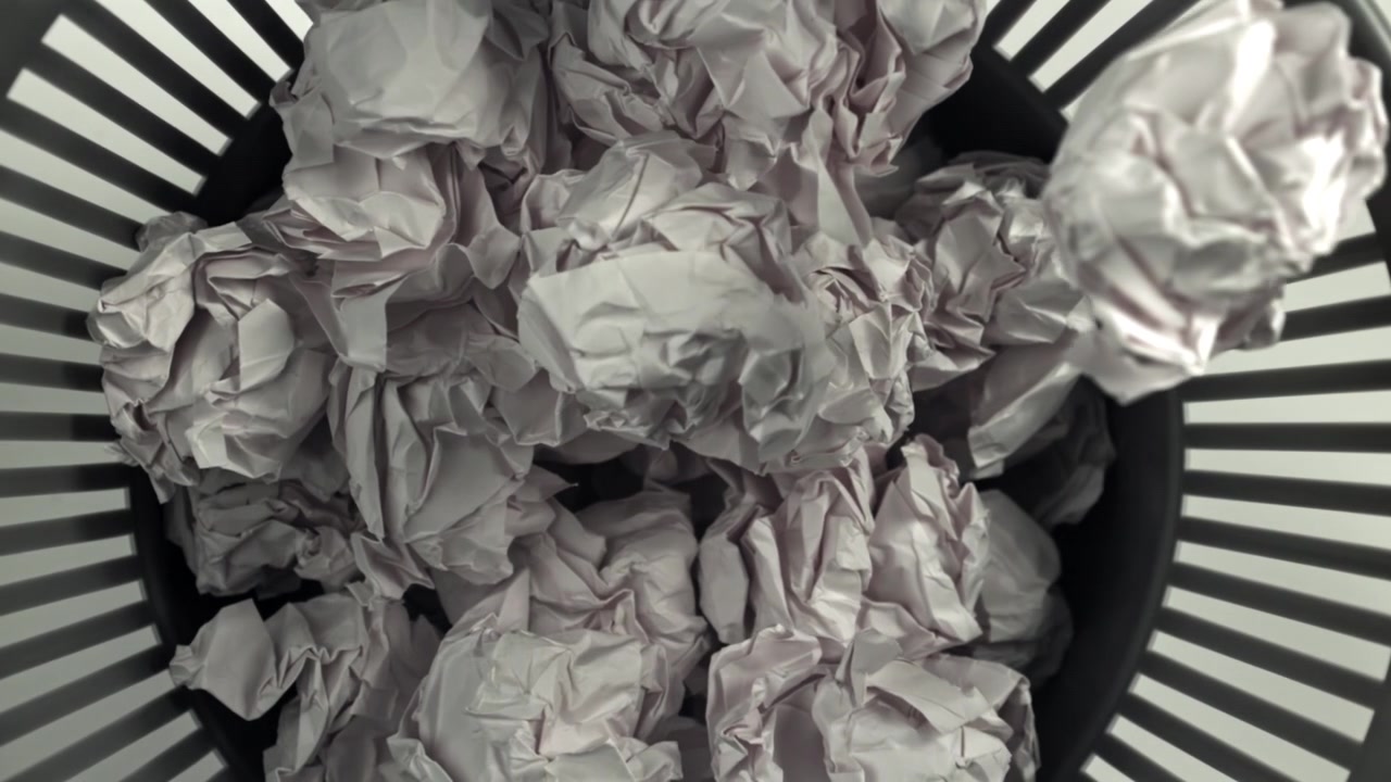 Crumpled Paper Balls Falling into a Wastebasket