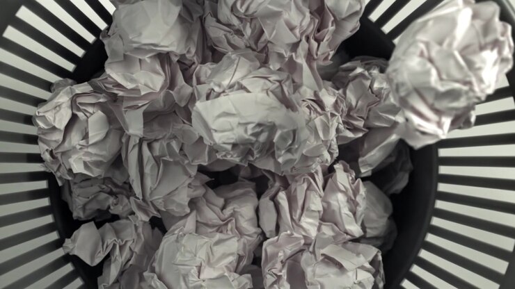 Crumpled Paper Balls Falling into a Wastebasket