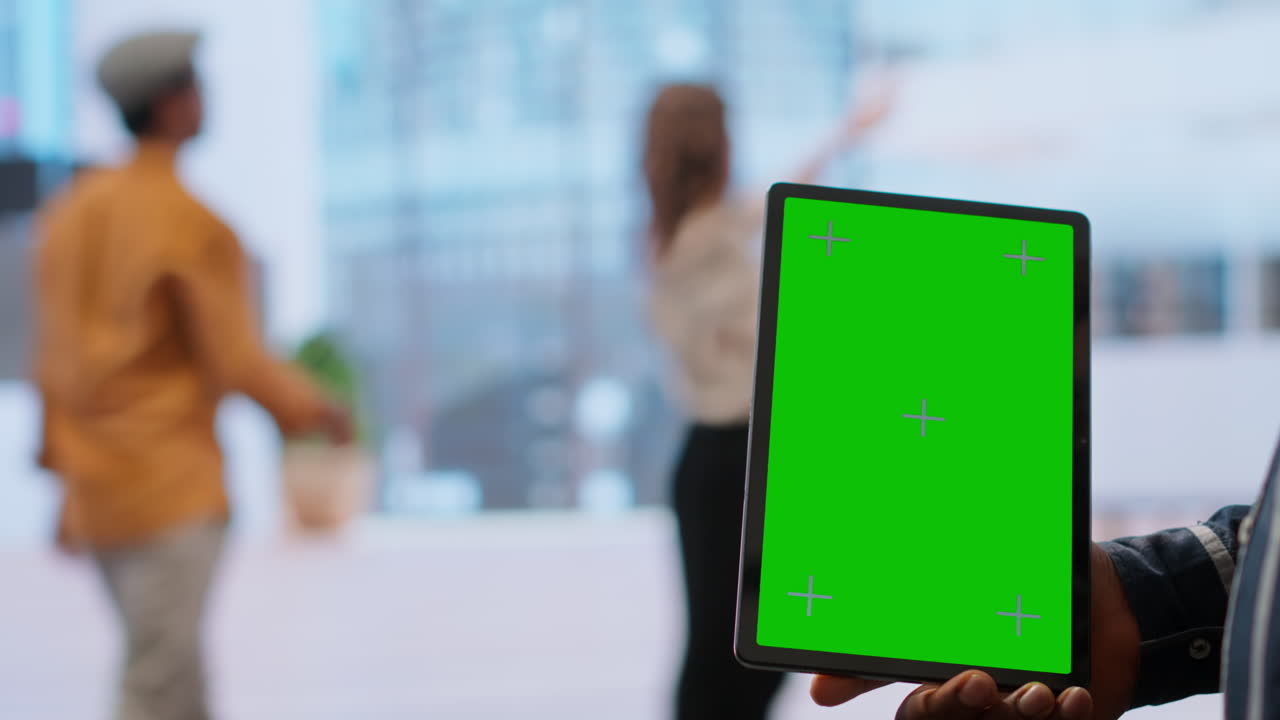 los agentes inmobiliarios y el cliente examinan los planos junto a una pantalla verde