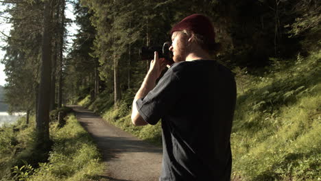 landscape photographer taking picture of the beautiful nature scenery near caumasee lake in switzerland on a sunny day - medium shot