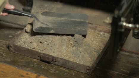 emptying ashes into ash pan from solid fuel stove