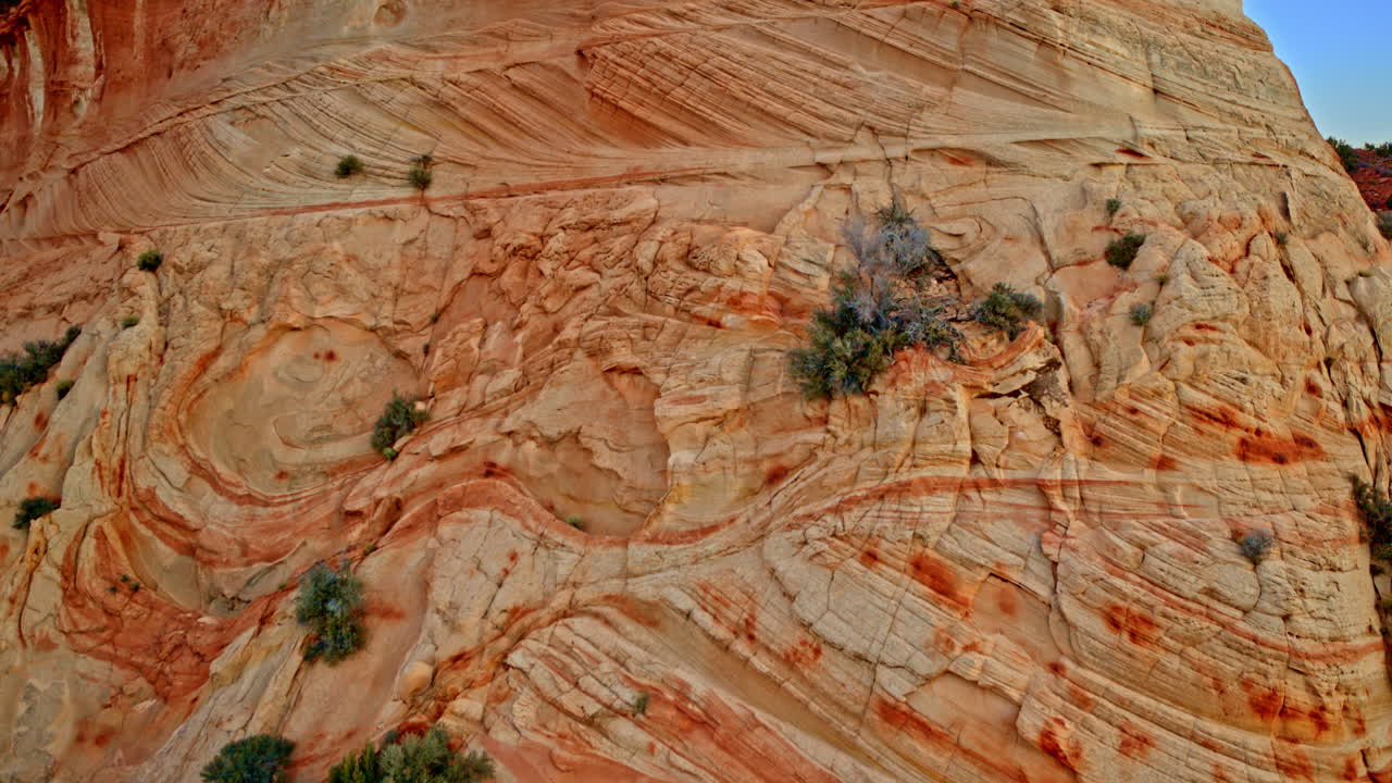 Aerial shot highlighting the rugged beauty of formations along the red canyon wall.