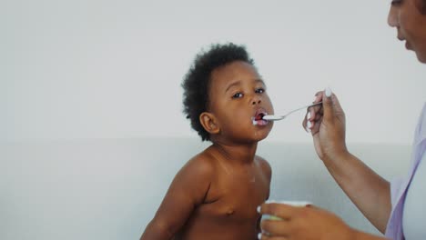 mother feeding baby yogurt