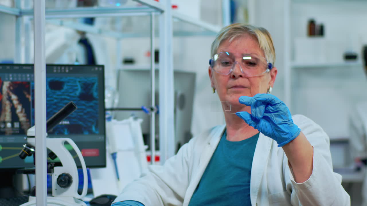 Senior woman lab technician looking at virus sample