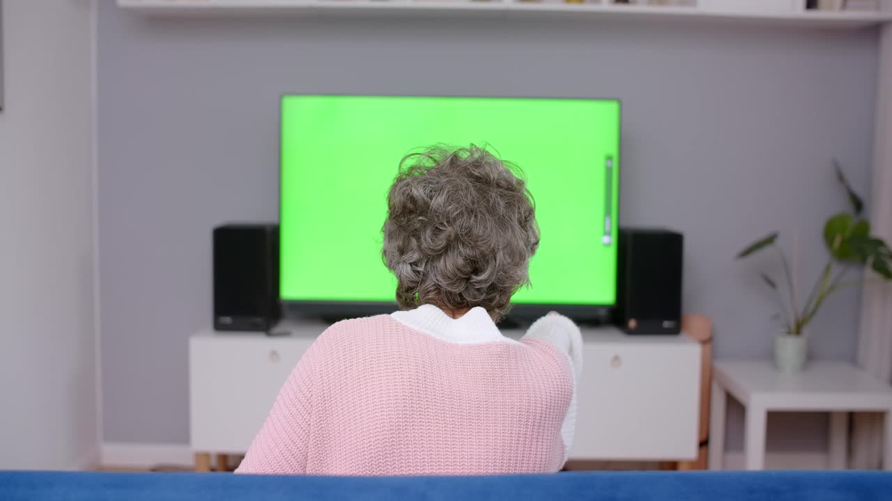 초록색 스크린에서 tv를 보는 여자