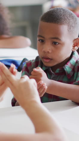 video de una feliz maestra caucásica enseñándole matemáticas a un niño afroamericano