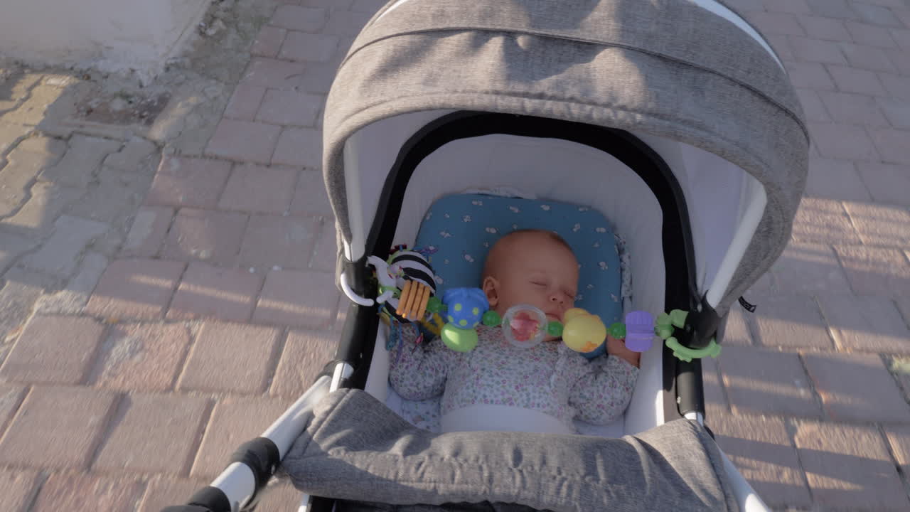 A cute baby girl sleeping in a moving baby carriage