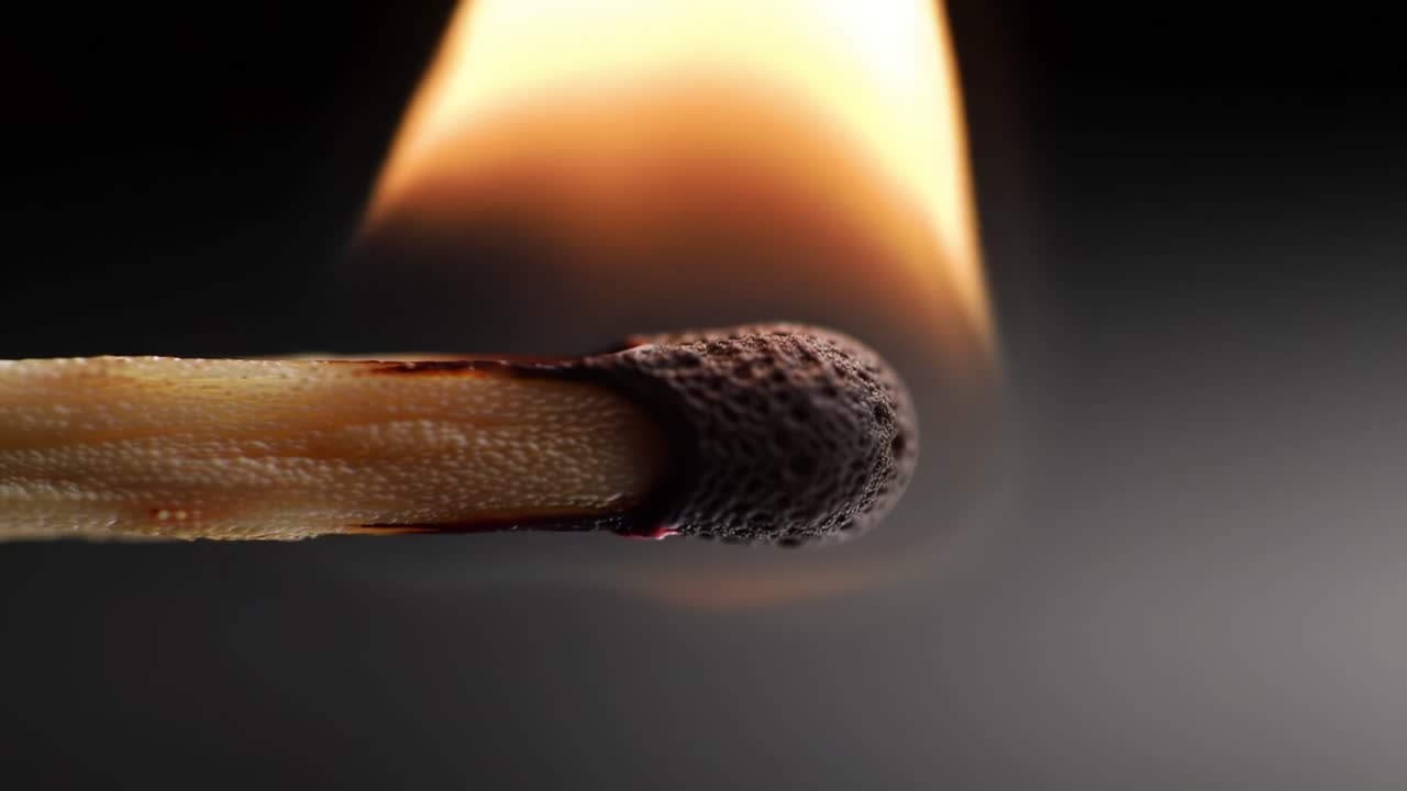 Close up of a Match Igniting and Flickering Flame in Low Light Setting