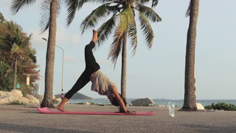 sporty woman doing workout on yoga mat by the ocean coast