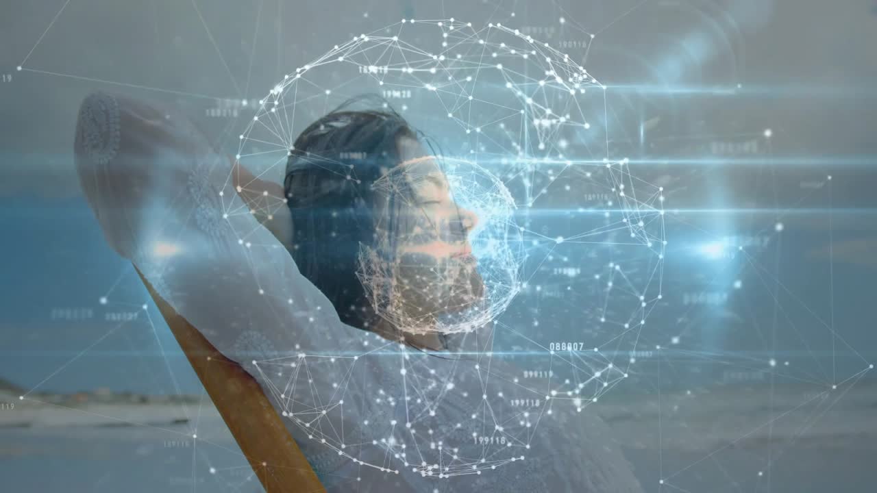 Návštěvník pláže odpočívající v křesle a spouštějící rotující datovou sféru vizualizující technologickou síť.