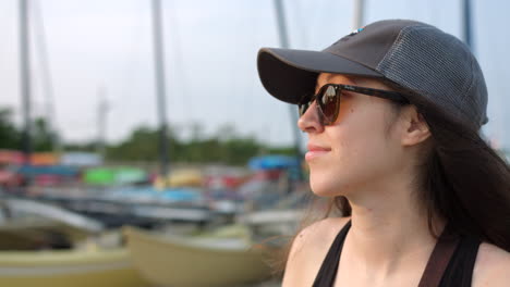 young girl wearing a cap and sunglasses looking afar and enjoying the view