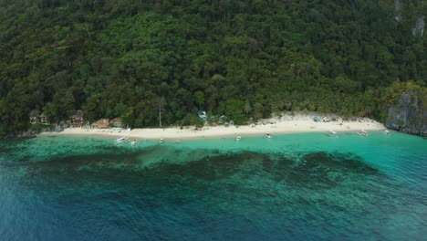 WS-AERIAL-Seascape-with-beach,-forest-and-boats,-El-Nido,-Palawan,-Philippines