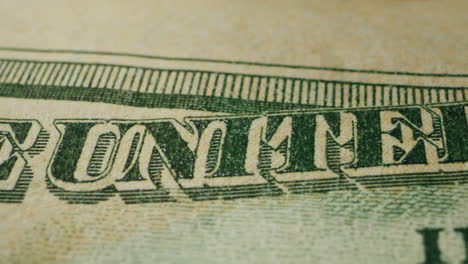 a closeup view of a fifty dollar bill on a polished wooden table, highlighting its intricate design