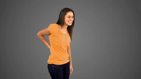 woman rubbing painful back on grey background