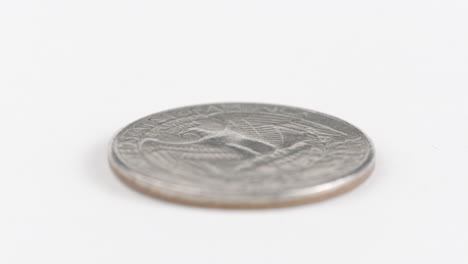 moneda de dólar de plata con un águila grabada en una mesa blanca