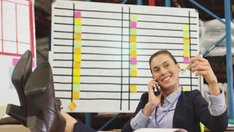 Glückliche-Junge-Frau-Am-Telefon-In-Einem-Lagerbüro-4k