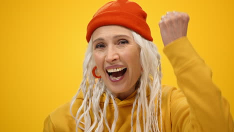 mujer de último año alegre divirtiéndose en el interior. dama sonriente bailando en un estudio moderno.
