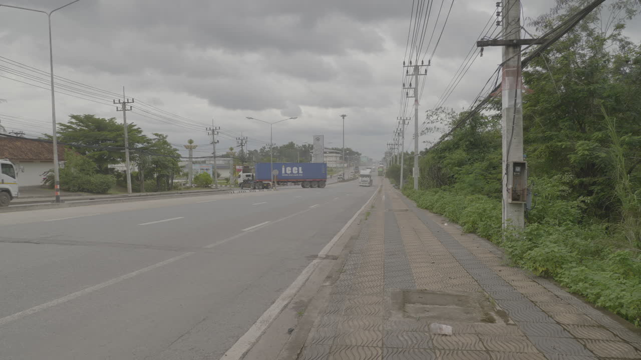 트럭 운전사가 있는 아시아의 도로, 정글 숲에 대한 보도, 흐린 날