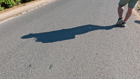 person walking, casting a long shadow