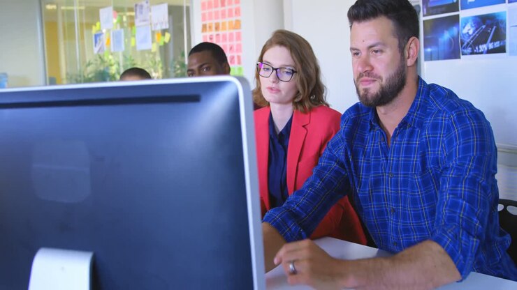 Young mixed race business team discussing over computer in modern office 4k