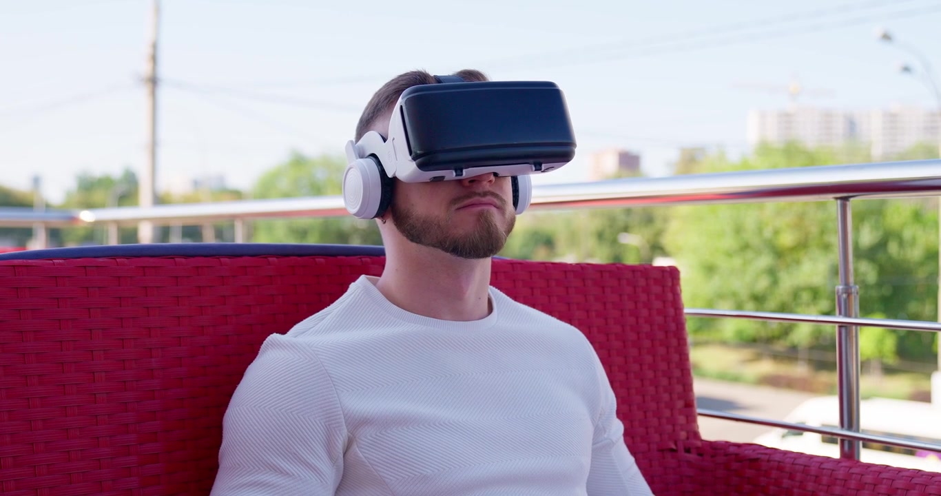 Bearded Man Using Virtual Reality Headset on an Outdoor Terrace