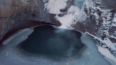 frozen waterfall with water running behind ice in winter tilt up