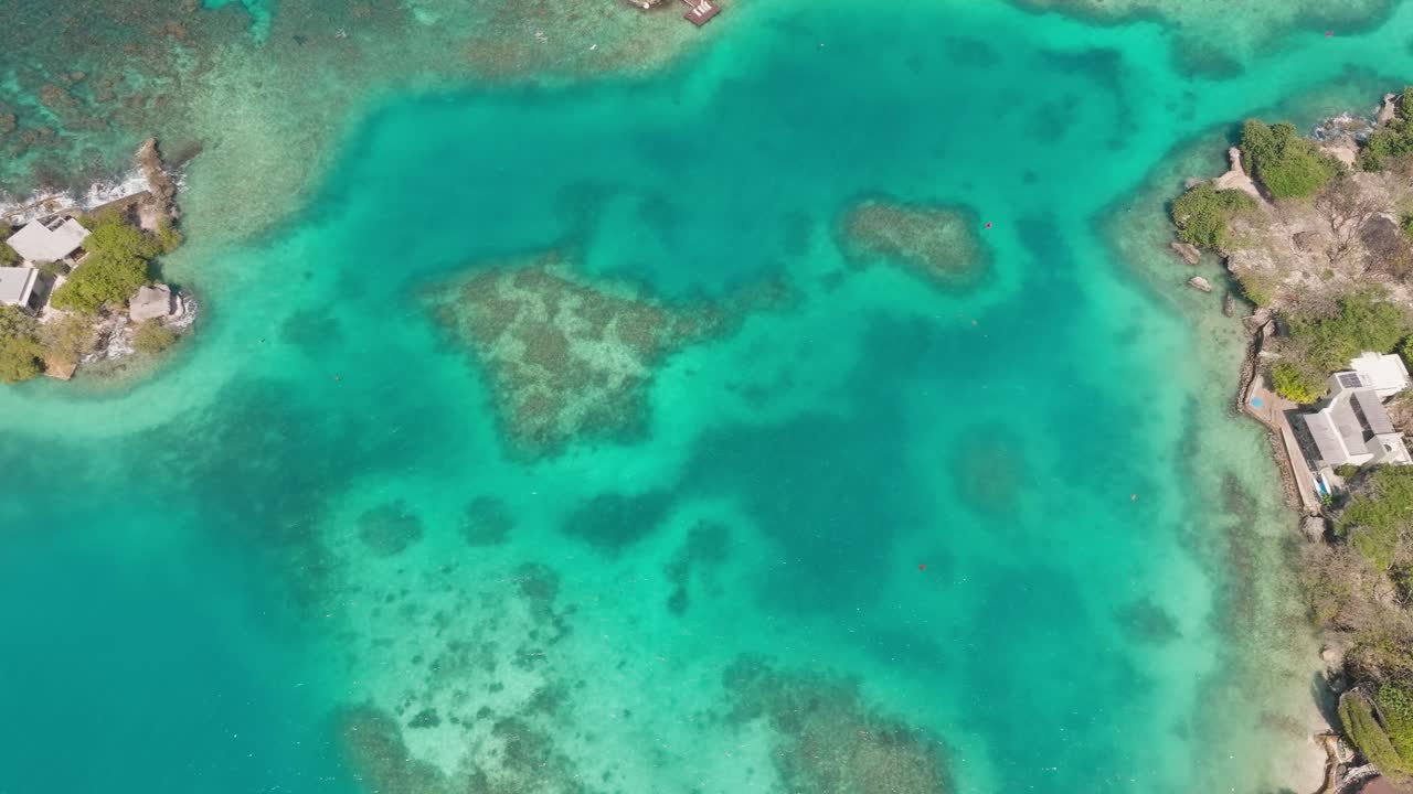 Drone view of Isla Grande in Rosario Islands, Colombia, surrounded by crystal clear Caribbean waters, coral reefs and lush tropical scenery