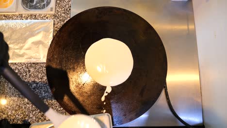 the chef pours pancake batter onto the frying pan