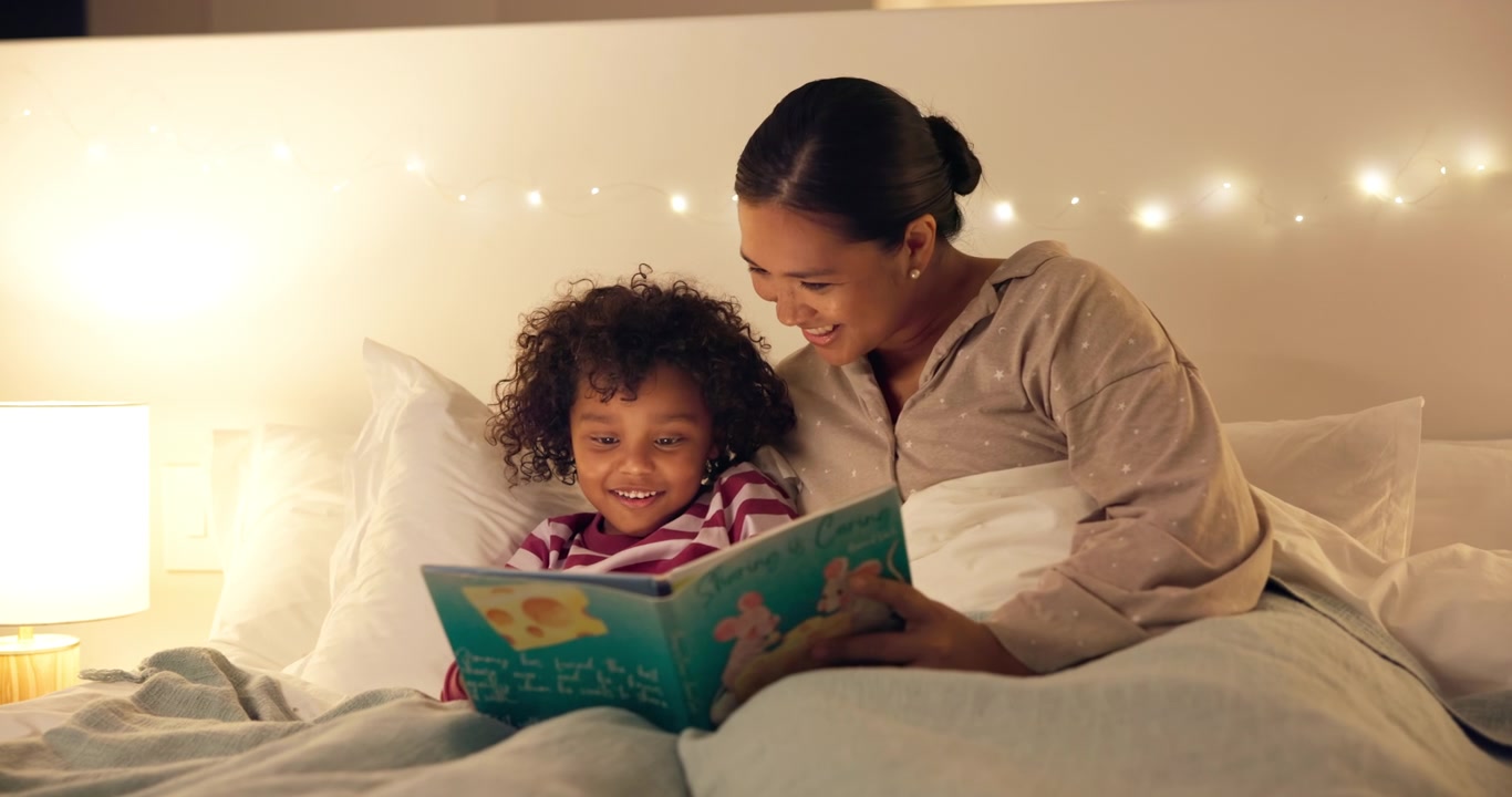 Mother Reading a Bedtime Story to Her Young Daughter in Bed