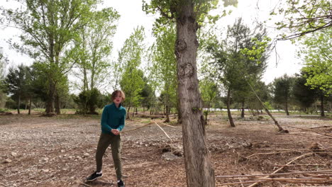 Adolescente-Sacando-Su-Ira-Rompiendo-Palos-Contra-El-árbol