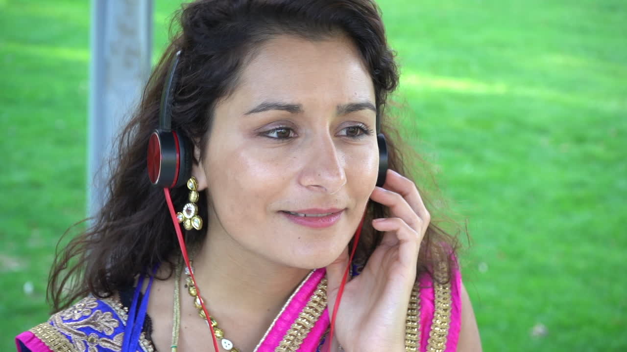 Portrait of a happy cheerful girl listening to music with headphones and dancing