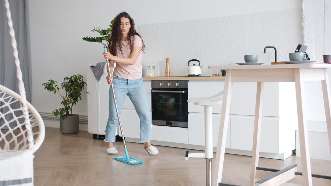 Woman Dancing While Mopping the Kitchen Floor