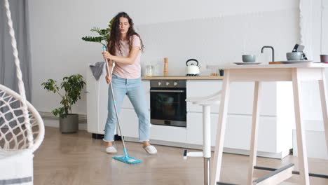 woman dancing while mopping the kitchen floor