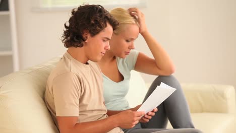 una pareja preocupada mirando un documento