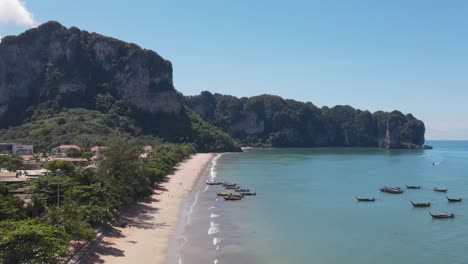 Ao-Nang-beach-with-cliffs-tourists,-and-longtail-boats