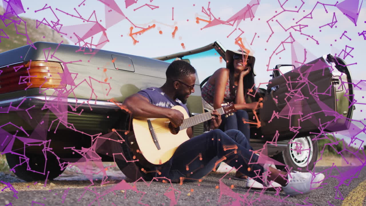 Man playing guitar next to car with colorful geometric animation overlay