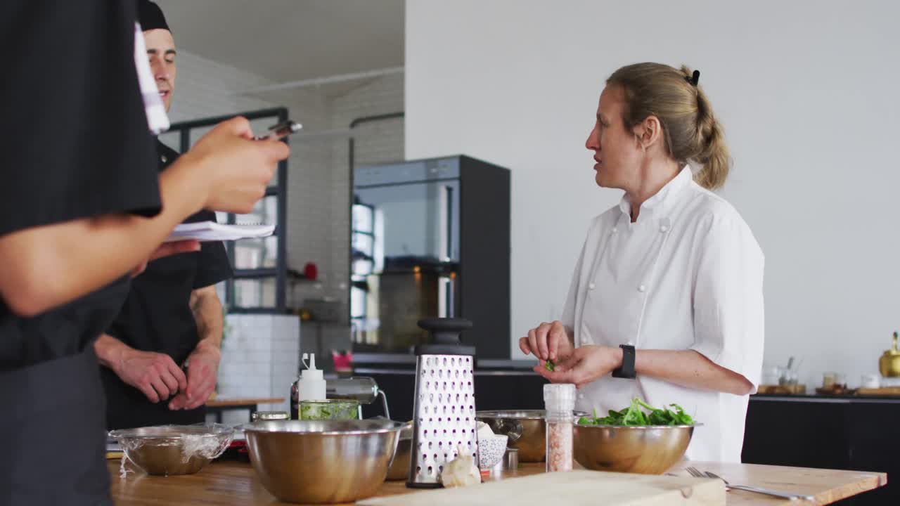 cocinera caucásica que enseña a un grupo diverso