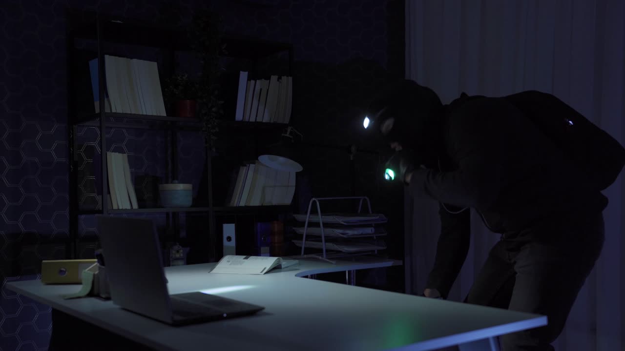 el ladrón, que vino a la oficina para robar, roba la computadora portátil.