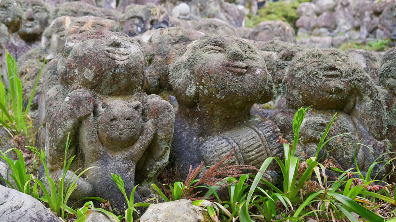 Moss-covered arhat statues covering the hillside around the temple grounds at the Otagi Nenbutsuji Temple in Kyoto, Japan