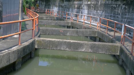 agua del río que fluye en un canal entre paseos y pasarelas de bangkok, tailandia - toma amplia