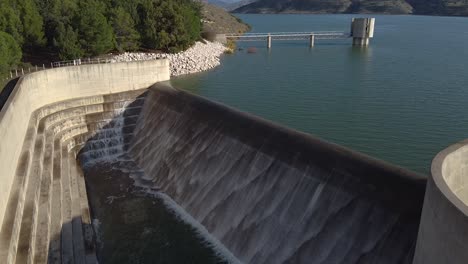 vista del embalse de la presa de asprokremmos desbordante con el puente y la torre de control al fondo