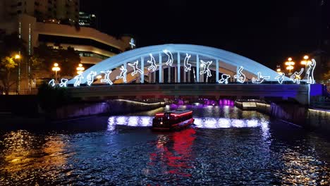 elgin bridge in singapore at night with bumboat and night lights of sportsmen during singapore bicentennial