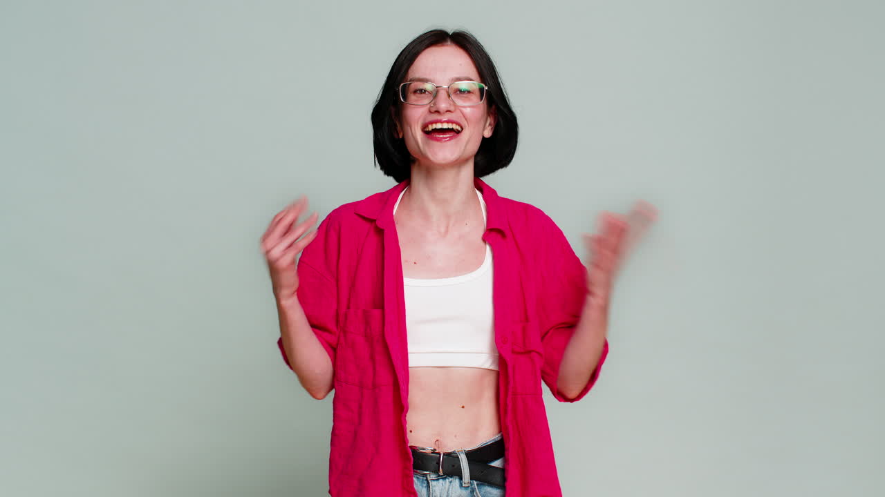 Young woman celebrating win with joyful smile expressing happiness success achievement excitement