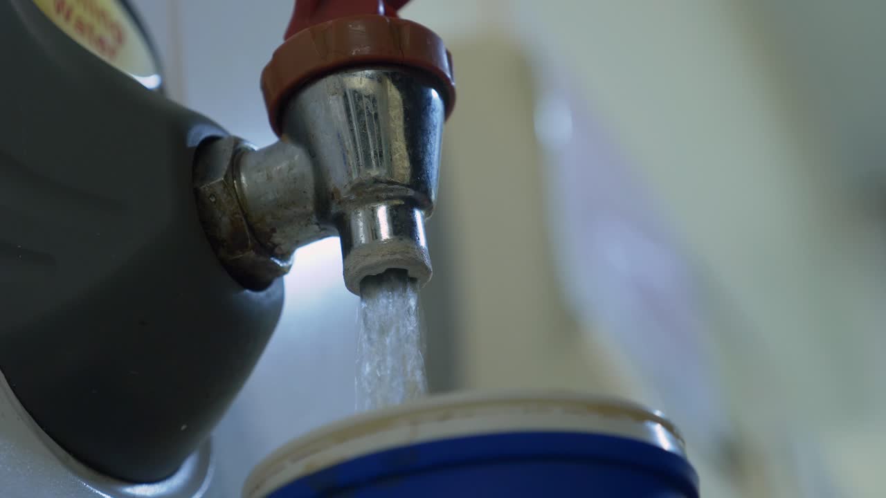 llenando una taza con agua caliente del dispensador de agua - disparo en ángulo bajo, primer plano extremo