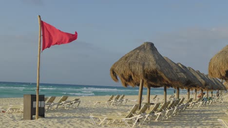 red flag posted along the empty shore of mexico beach warning people not to swim in the area